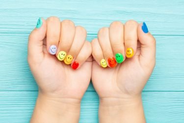 female-hands-with-multicolored-manicure-closeup-manicure-with-smile-emoji